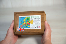 Load image into Gallery viewer, Two hands hold a brown wooden box. on the box lid is the label showing the details of the Countries of Europe Jigsaw Puzzle